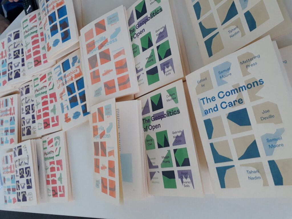 Zines of various colours arranged on a white table surface