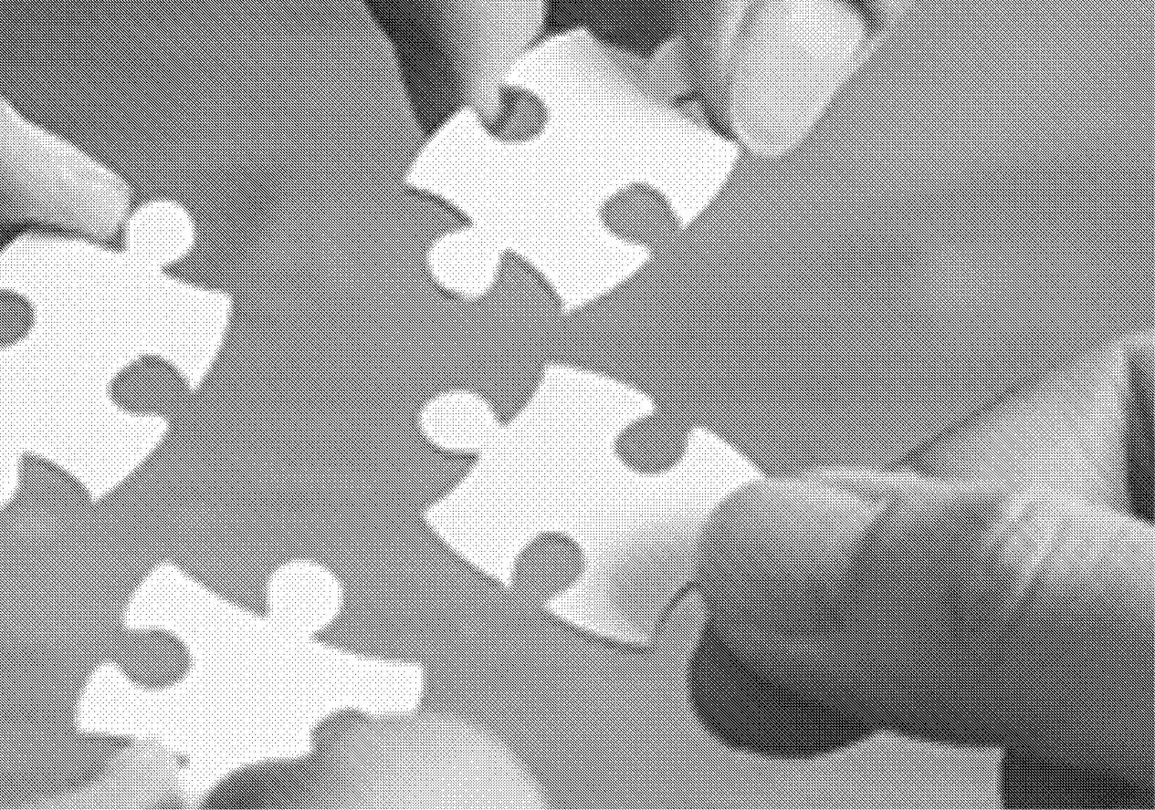 four hands hold white jigsaw puzzle pieces